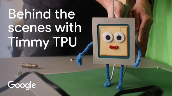 A still from the animated short film "TPU Training Day." It features a stylized, friendly robot character named Timmy TPU, uniquely crafted with a tactile, human-made aesthetic resembling cardboard textures and hand-drawn marker lines.