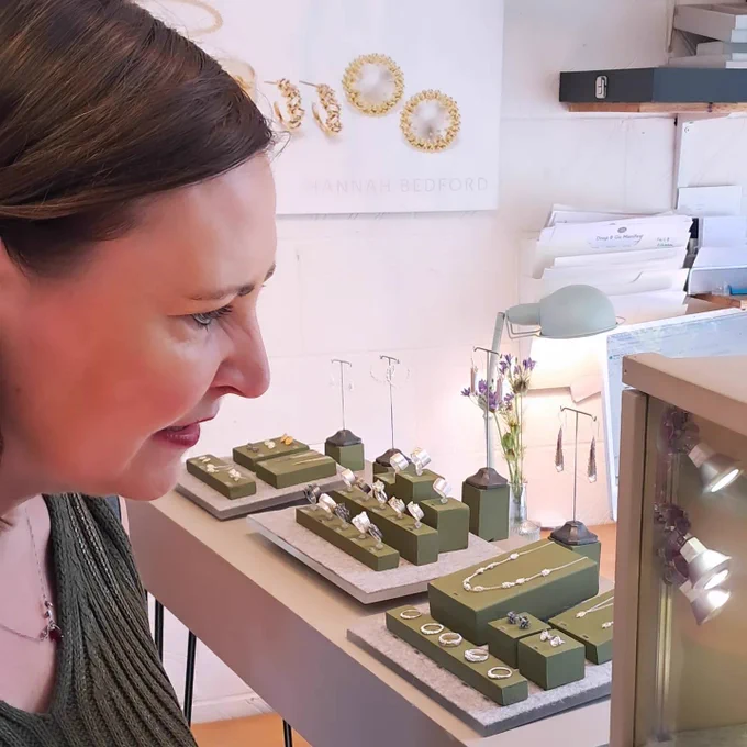 A photo of Vicky looking at jewellery by Hannah Bedford in display cabinets.