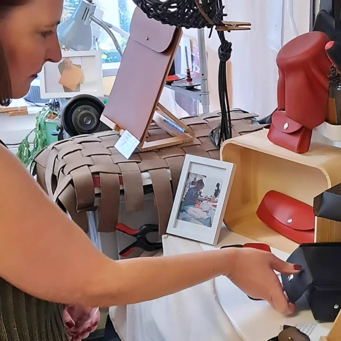 A photo of Vicky touching a handmade leather purse by Deco 22