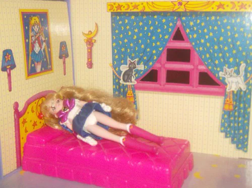 Sailor Moon taking a nap inside her dream house.