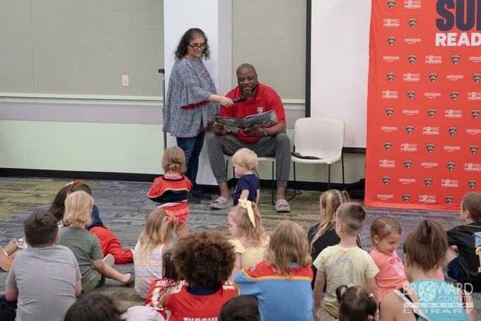 A former Panthers player reading to a group of children