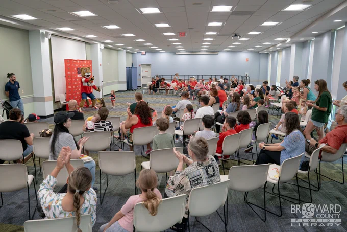 A large library auditorium filled with people while Stanley stands in front of them