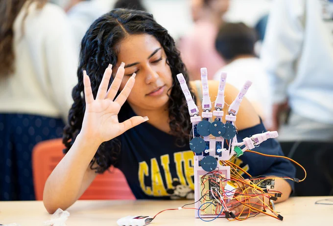 A student with a robotic hand in Mechanical Engineering 102B, Mechatronics class, taught by professor Lining Yao during Jacobs Institute’s 2025 Spring Design Showcase in 2025. 