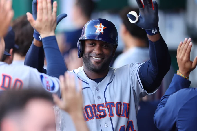 Yordan Alvarez high-fives his teammates in the dugout Friday night. He wears a gray Astros uniform with navy lettering and orange trim.
(Photo: Tanner Gatlin/Major League Baseball)