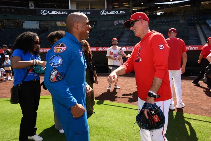 NASA Astronaut Victor Glover and Angels Pitching Coach Mike Maddux share a laugh together on the field at Angel Stadium. 