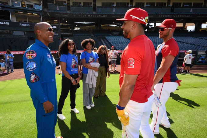 NASA Astronaut Victor Glover chats with Oswald Peraza and Logan O'Hoppe during the team's batting practice at the Big A. 