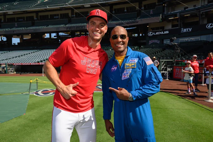 Brent Suter and NASA Astronaut Victor Glover smile for a photo together on the field at Angel Stadium. 