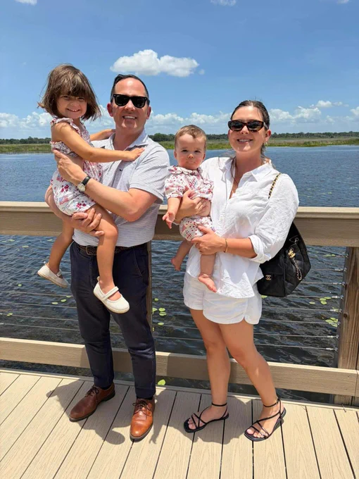 A family of four enjoys a sunny day by a lake, exuding joy and togetherness.