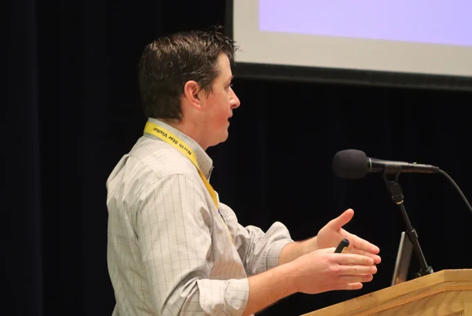 A man speaks into a microphone at a podium