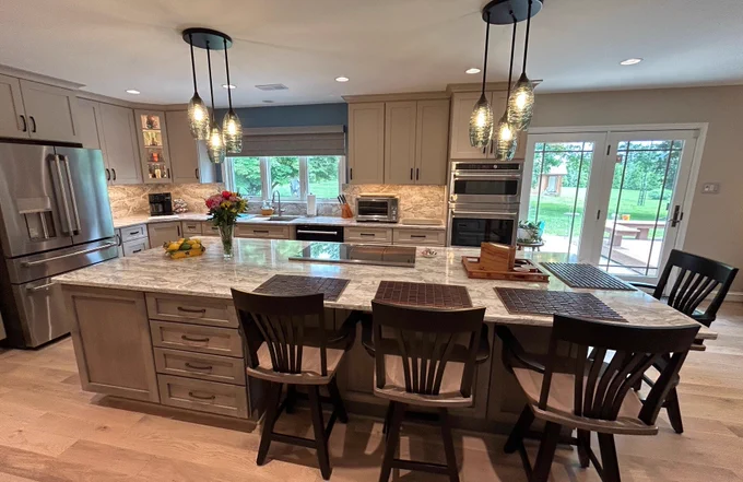 Thinking about a kitchen remodel in the Frederick, MD area? Here’s a closer look at one of our recent projects by Talon Construction Inc. - Q&A style:
Q: What makes this kitchen stand out?
A: The oversized island is the centerpiece designed for cooking, gathering, and entertaining all in one space. It’s both functional and a true focal point.
Q: What materials were used for the countertops and backsplash?
A: Vicostone Moonglade Quartz was selected for both the countertops and full-height backsplash, creating a seamless, high-end look with excellent durability.
Q: How does the cabinetry design enhance the space?
A: The combination of light upper cabinets and contrasting gray base cabinets adds depth while keeping the kitchen bright and open. Clean lines and modern hardware complete the look.
Q: What storage solutions were incorporated?
A: This kitchen is packed with smart storage with deep drawers, pull-out organizers, a custom pantry, and built-in features that keep things organized.