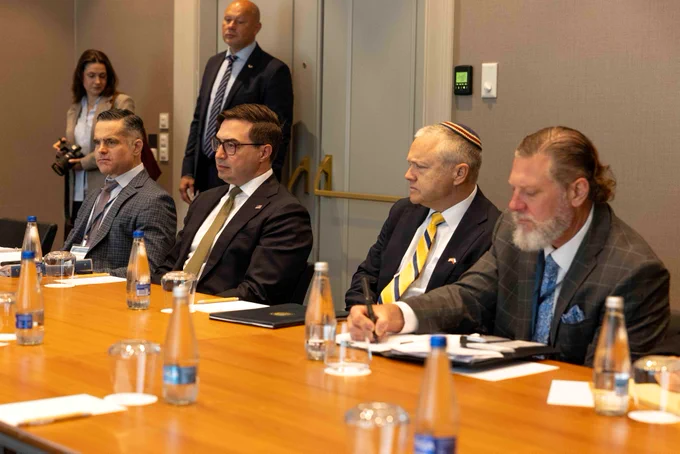 Photo featuring A/S Haines sitting and listening.