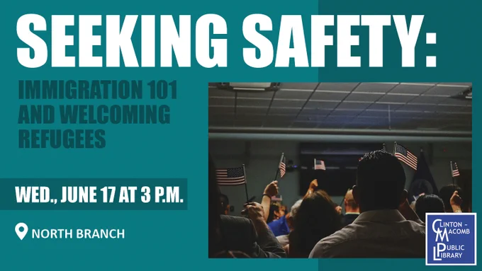 People gathered indoors waving small American flags during a Seeking Safety event about immigration and welcoming refugees.