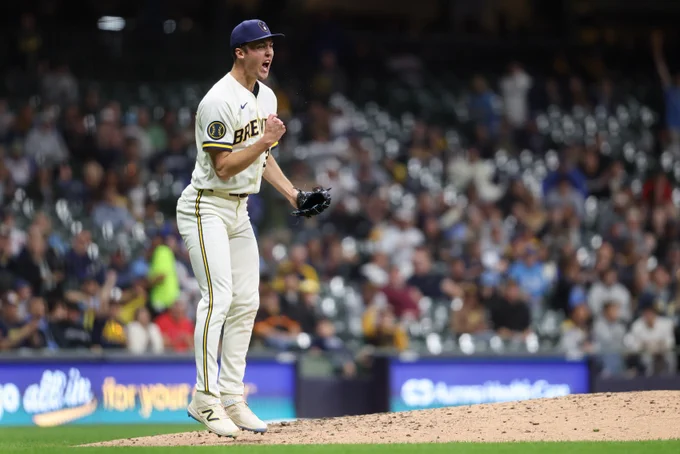 Jacob Misiorowski pumps his fist in celebration during a game. He is wearing a cream-colored Brewers uniform and a dark blue cap.