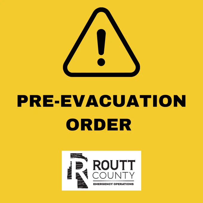 Yellow warning sign with an exclamation mark and bold text stating PRE-EVACUATION ORDER from Routt County Emergency Operations.