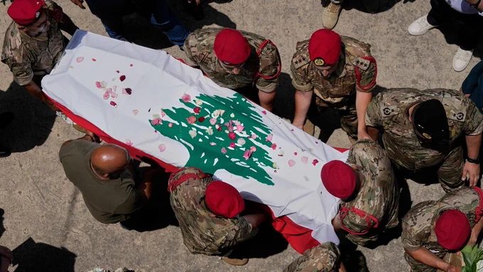 6月8日、レバノン南部クファル・ジャラで、イスラエル軍の空爆で死亡した軍幹部の棺を運ぶレバノン軍兵士たち（写真：AP/アフロ）