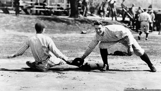 Lou Gehrig wearing a pinstripe uniform and applying a tag to a sliding runner. (National Baseball Hall of Fame and Museum)