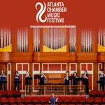 A group of musicians performs on a stage at Emory's Schwartz Center, with wood paneling and organ pipes in the background with the display reading "Atlanta Chamber Music Festival." 