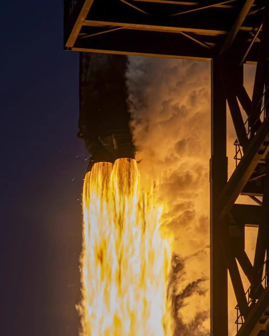 A rocket engine on a launch pad, emitting bright flames and thick smoke, creating a dramatic and powerful scene.