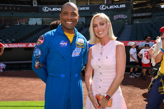 NASA Astronaut Victor Glover poses for a photo with ABTV broadcaster Erica Weston on the field at Angel Stadium. 