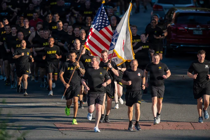 Secretary of the Army Daniel P. Driscoll, Vice Chief of Staff of the Army Gen. Christopher C. LaNeve, and Sergeant Major of the Army Michael R. Weimer lead a large formation of Soldiers during the Army's 251st Birthday Run at Joint Base Myer-Henderson Hall, Virginia, June 12, 2026. Color guards carry the American flag and the U.S. Army flag directly behind the leadership team.