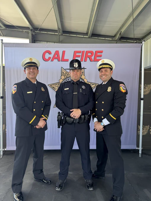 CAL FIRE firefighters standing in front of a CAL FIRE law-enforcement background