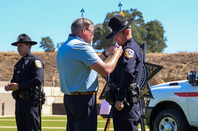 Fire Captain Roman having his badge pinned.