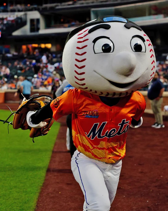 Pictured: Mr. Met is recreating the famous "Naruto run" from the anime with their arms out to the side, Naruto. He wears an orange Naruto-Mets jersey with a Leaf Village forehead protector.