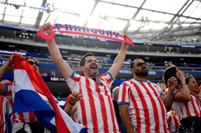 Fans of Paraguay cheer for their team at Los Angeles Stadium.