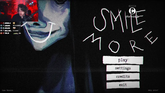 Screenshot of Cellbit's stream. His webcam is located on the top-left corner. The starting screen of 'Smile More' is open, with the options 'play', 'settings', 'credits', and 'exit' below the title.