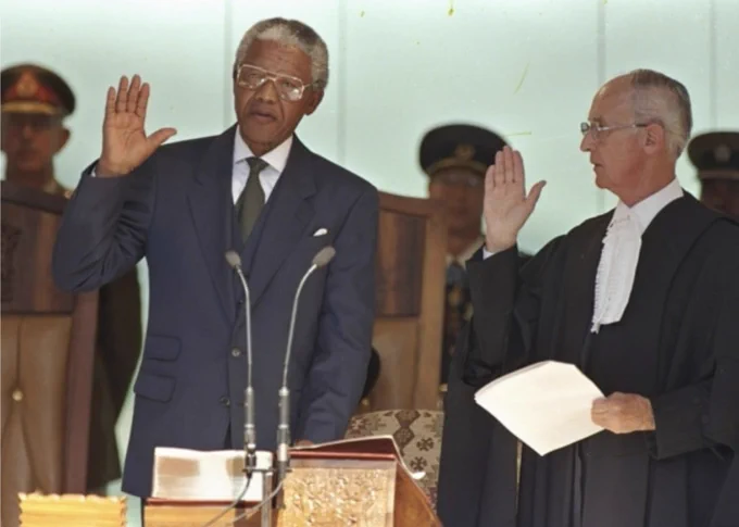 In this May 10, 1994, file photo, Nelson Mandela, left, takes the oath of office in Pretoria, South Africa, to become the country's first black President.