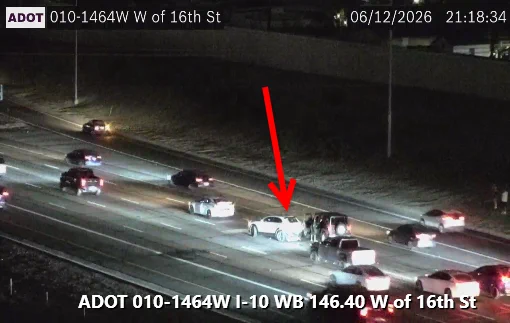 A vehicle collision on a highway at night, involving a light-colored car and a dark-colored SUV. Traffic is present on multiple lanes. The image is from ADOT, timestamped June 12, 2026, at 21:18:34, showing location I-10 WB 146.40, near 16th Street.