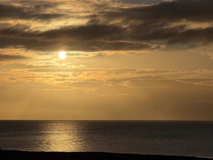 Sun rising above low clouds