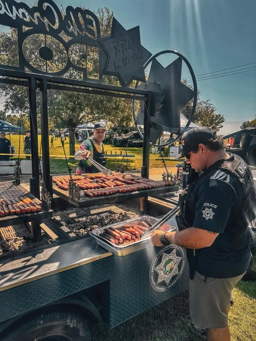 Photo of Elk Grove Police Officers BBQing hot dogs and hamburgers for Elk Grove's free BBQ in the Beat event.