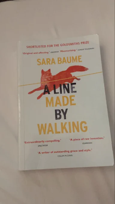 A book—A line made by walking by Sara Baume, with an illustrated fox  crossed out with a yellow line on the cover