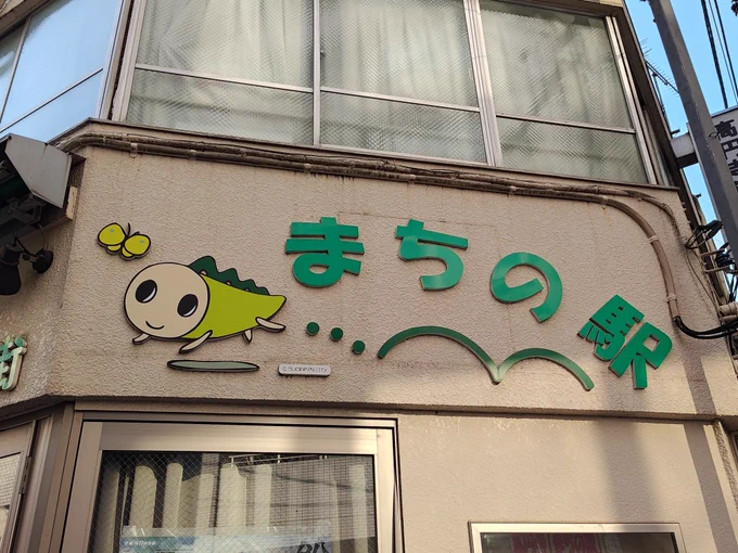 まちの駅、と書かれた壁と蝶々を見つめるなみすけ