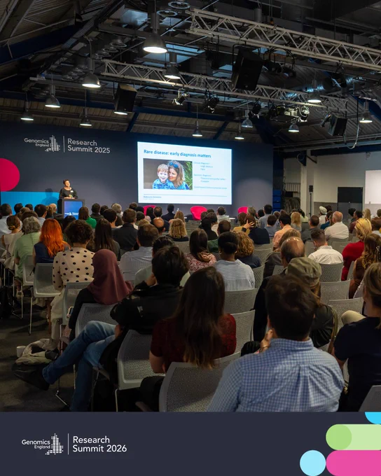 Large audience listening to a speaker presenting on rare disease diagnosis at the Genomics England Research Summit 2025.