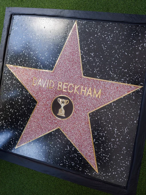 David Beckham's Hollywood Walk of Fame star embedded in a black terrazzo tile with gold lettering and a trophy emblem in the centre.