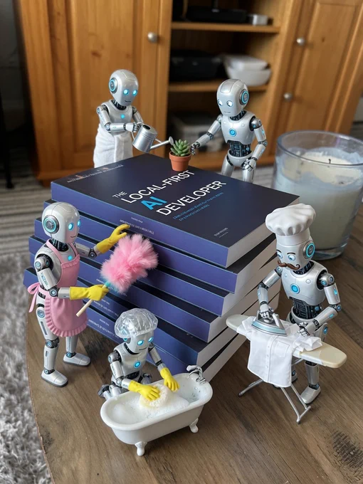 A stack of copies of Rob's first book "The Local-First AI Developer"  sitting on his coffee table at home, AI robots surround it doing menial manual labour