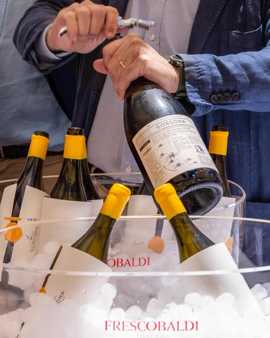 Close-up of Frescobaldi Gorgona wine bottles chilling in ice as a bottle is opened during the official presentation of the 2025 vintage in Tuscany, Italy.
