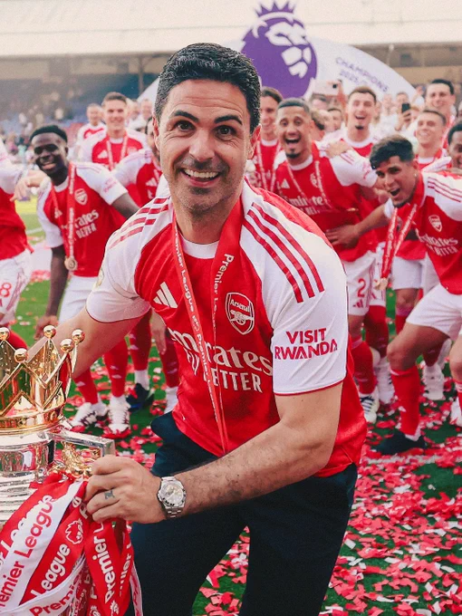 Mikel Arteta spins with the Premier League trophy before raising it to the Arsenal fans at Selhurst Park. 