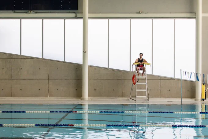 UTM RAWC indoor pool with lifeguard sitting in chair observing pool
