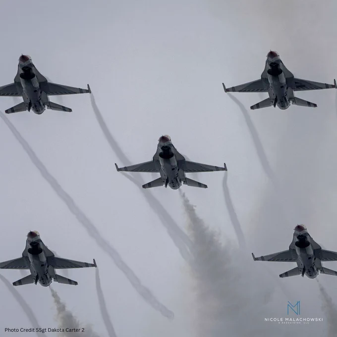 Five fighter jets flying in formation with smoke trails across a cloudy sky.