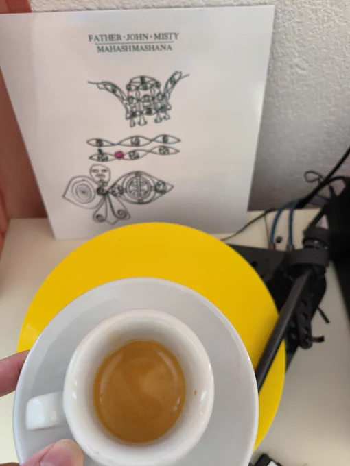 Gehaltene Espressotasse vor dem Plattencover von father John misty 