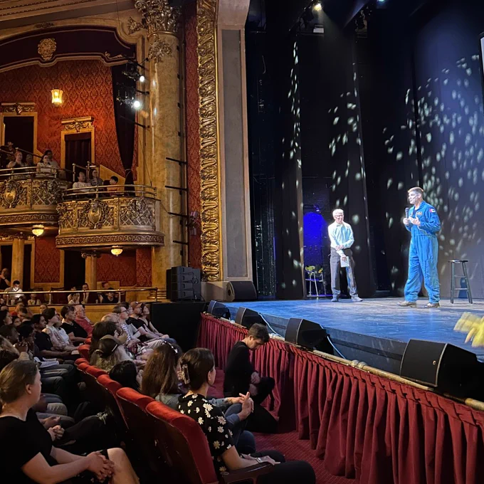 Astronaut Jeremy Hansen giving a presentation on stage at an event.