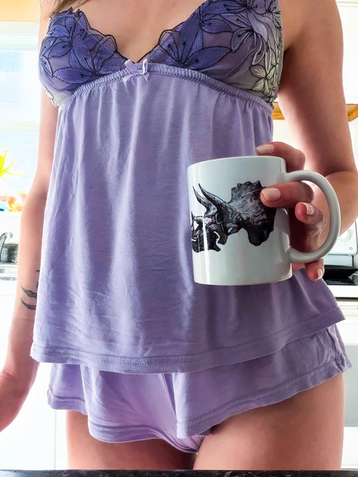 a brunette standing in her kitchen, coffee in hand