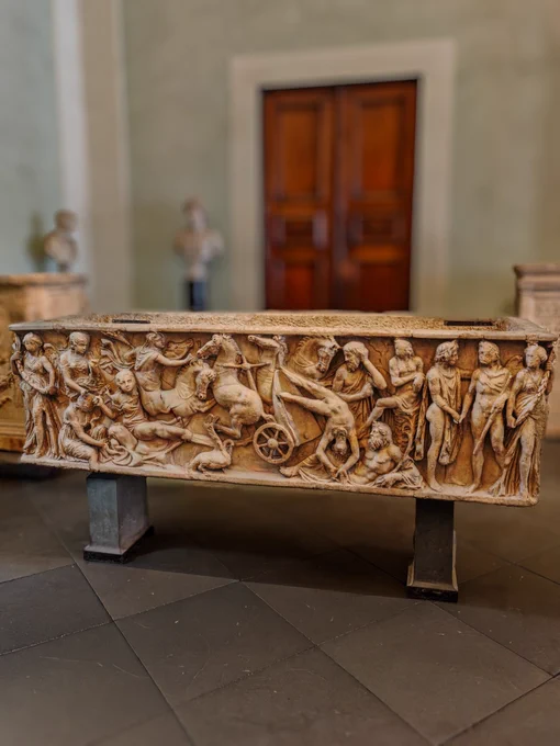 SARCOPHAGUS WITH THE FALL OF PHAETHON, C. 170-180 CE. GALLERIE DEGLI UFFIZI.

​This high-relief marble Roman sarcophagus once stood at the top of the Aracoeli steps in Rome and was a powerful influence on C16 art. Its deeply-undercut relief unfolds from left to right, capturing a narrative that dissolves into utter chaos. On the far left, Phaethon's grieving sisters, the Heliades, begin their transformation into poplars. The scene then erupts into a frenzied central spectacle where the four panicked chariot horses of the sun rear and twist violently in different directions above a small waterbird and the reclining river god Eridanus. On the right, calm divine figures witness the cosmic aftermath. The piece's true focus is the tragic figure of Phaethon himself, his limbs outstretched like the rays of the sun as he spins headfirst out of his chariot toward eternity, forever trapped in the terrifying moment just before his death.
