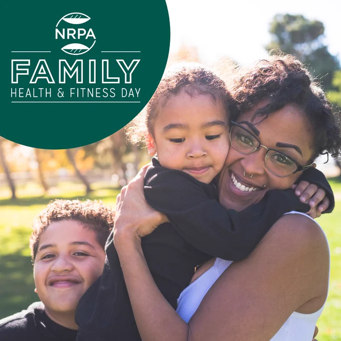 Mother embracing two children outdoors on a sunny day promoting NRPA Family Health & Fitness Day.