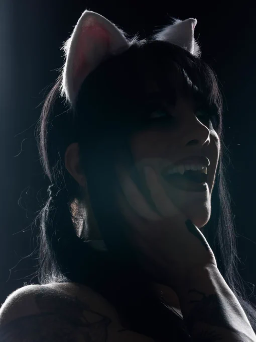 Tatum Paxley, a professional wrestler signed to WWE, posing for a closeup photo while wearing wrestling gear inspired by Rouge The Bat from the Sonic The Hedgehog media franchise, smiling with her mouth open to show off her fangs.