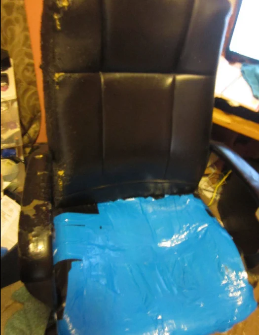 Pic of an office chair whose seat is covered in blue duct tape.