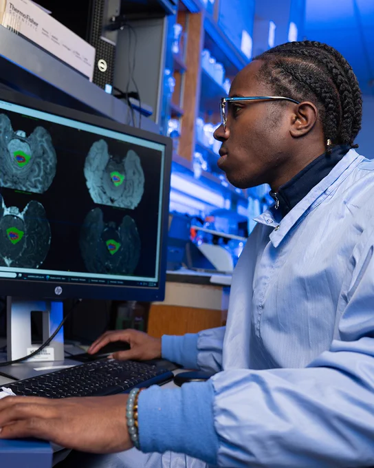 Diala Ajaero looks at images of brain scans on a computer in a lab